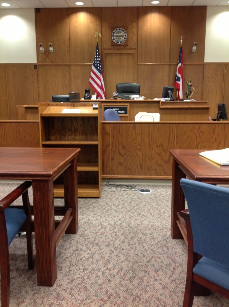 picture of an empty courtroom with all wood details and a beige carpet