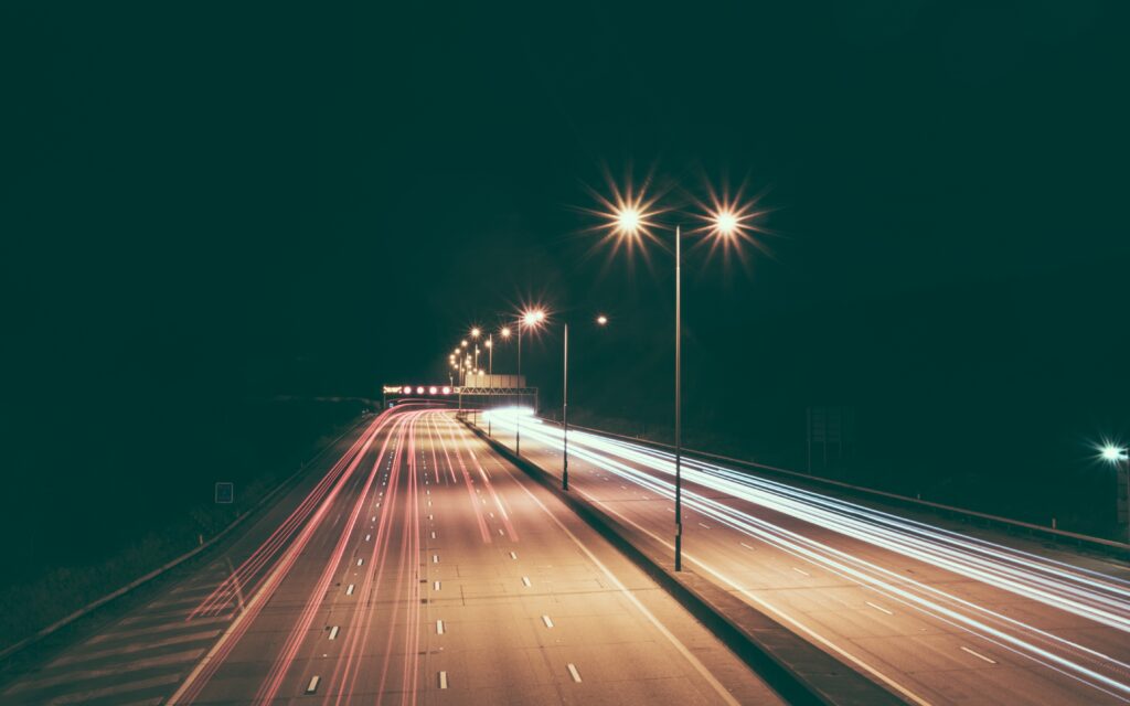 Dark, eerie empty highway at night in Florida under dim streetlights, setting a true crime atmosphere.