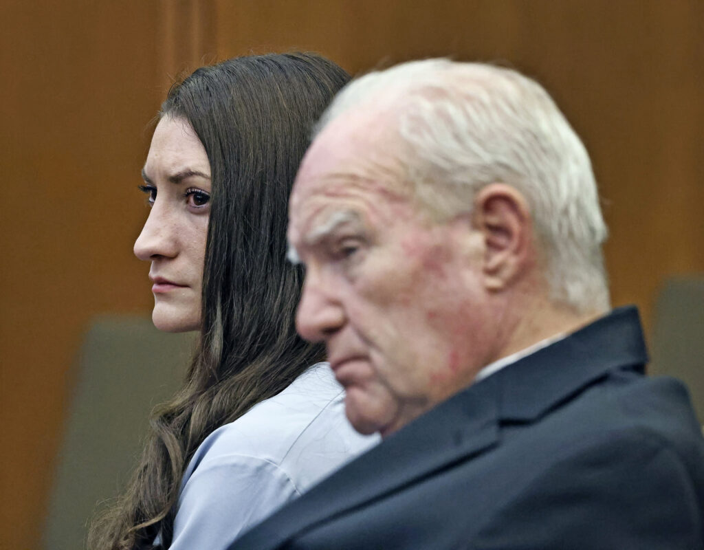 Lindsay Clancy and her lawyer sit in a courtroom with serious looks and red eyes on their faces during closing arguments