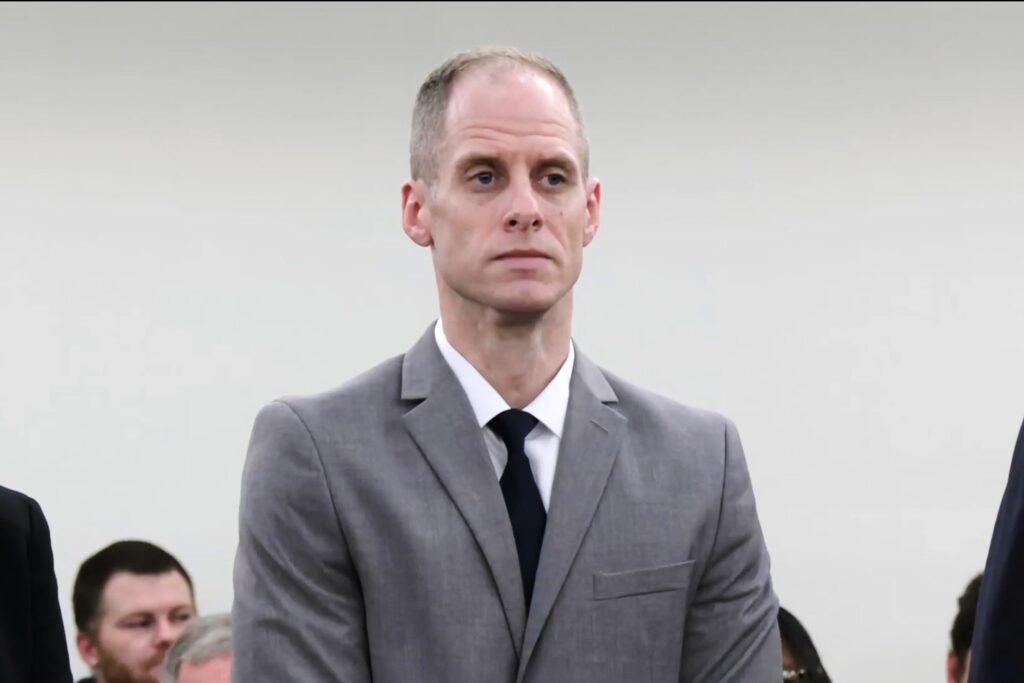 Former music pastor Caleb Flynn wearing a grey suit in an Ohio courtroom, looking visibly emotional as a legal verdict is delivered.