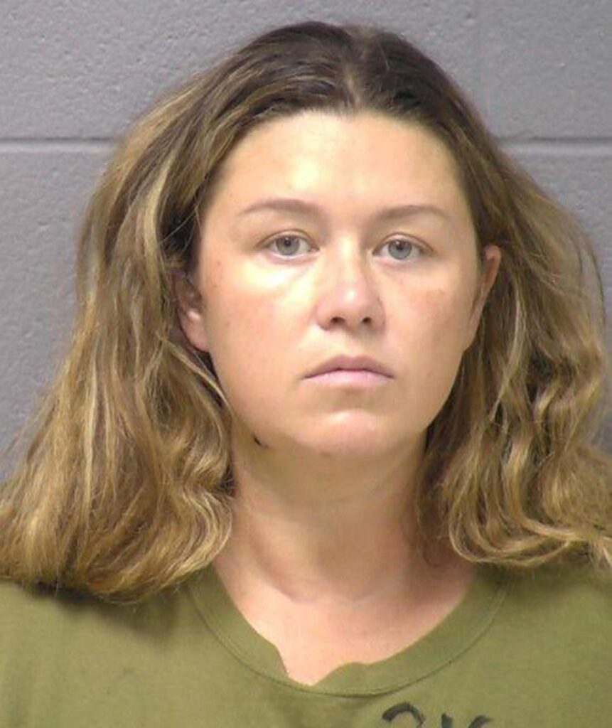 mug shot of Corie Walsh with bush light brown hair and an army green t-shirt looking disheveled