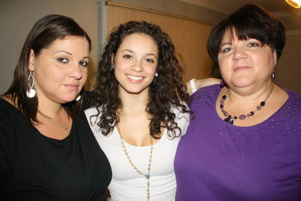 A personal family photograph featuring three women standing closely together and smiling. In the center is nineteen-year-old Faith Hedgepeth, flanked by her older sister Rolanda on her right and her mother Connie on her left during a birthday celebration.