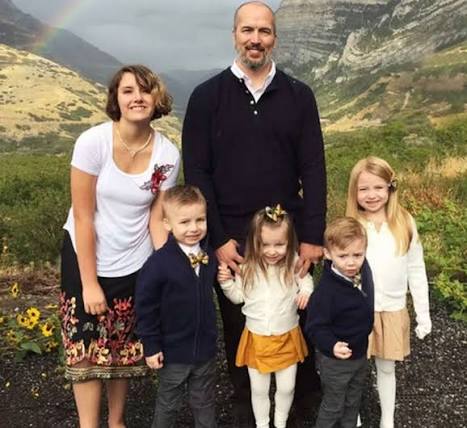 A family photo showing the father Brady Harmon smiling alongside his four children, Harper, Hudson, Gavin, and Gracelynn, in an outdoor setting. 