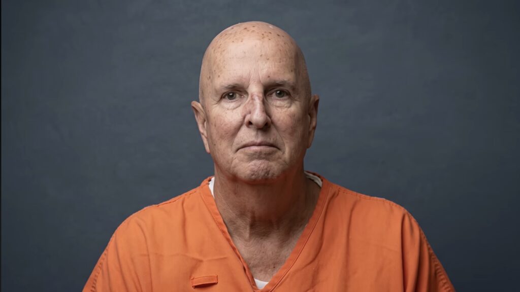 inmate photo of James Duckett  in orange jumpsuit with a bald headd and emotionless face