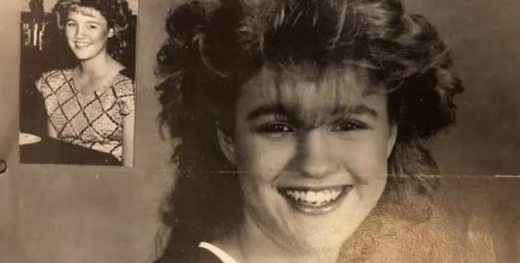 high school picture of Jeanifer Weldon in B&W with a big smiled and winged 80's hair